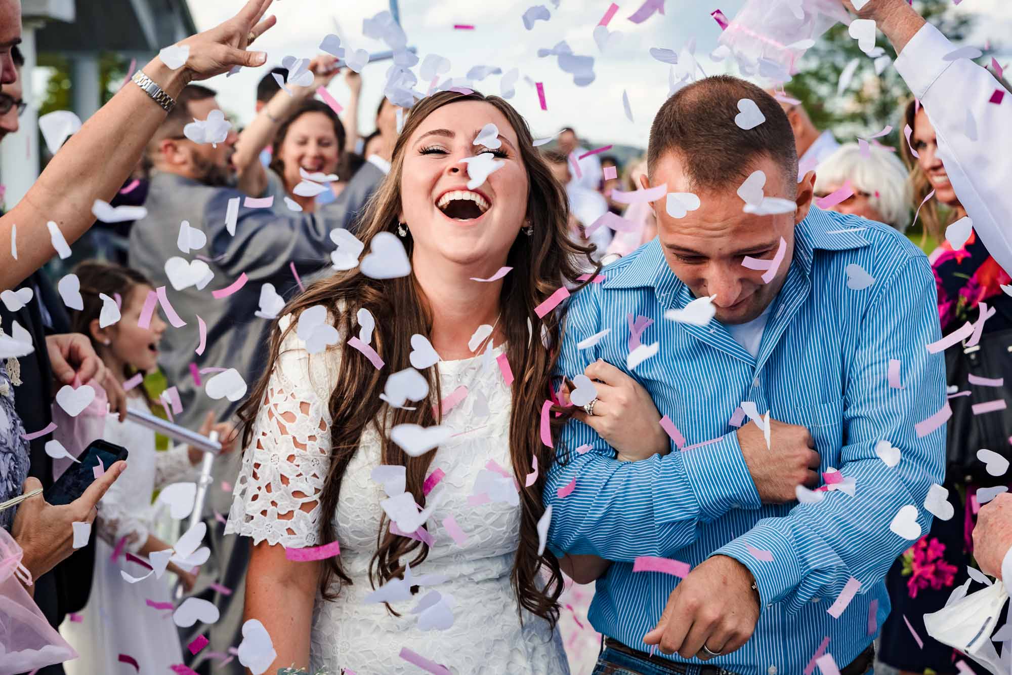 Bride laughing in confetti shower