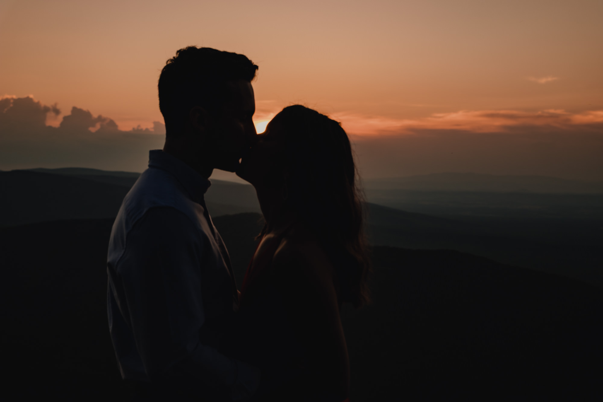 Couple silhouette kissing at sunset